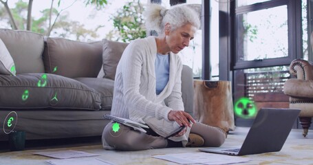 Fototapeta premium Sitting mature woman in light cardigan working on laptop with documents at home, with AR icons