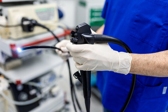 Surgeon holding endoscope for gastroscopy procedure. Medical equipment, Healthcare And Medicine concept. Close up of doctor hands in gloves holding fiber optic camera for internal examination.
