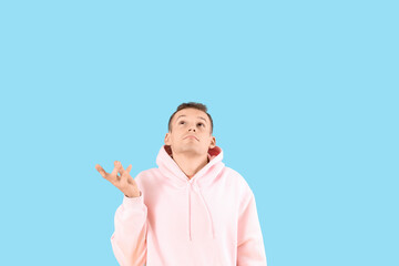 Fototapeta premium Wondering young man on blue background