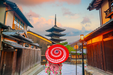 Girl wearing a traditional Japanese kimono with red umbrella  at old town  Kyoto, Japan