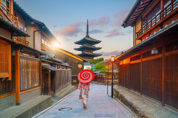Girl wearing a traditional Japanese kimono with red umbrella  at old town  Kyoto, Japan
