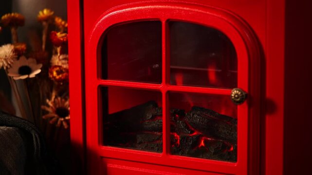 A warm and inviting winter scene with a retro red fireplace.