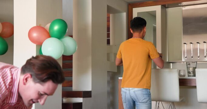 Dancing joyfully at home, gay couple celebrating festive occasion together