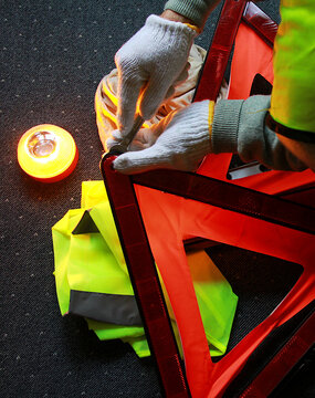 Reparando y arreglando aver&iacute;a con tri&aacute;ngulo y chaleco reflectante, baliza homologada de seguridad y emergencia con herramienta 