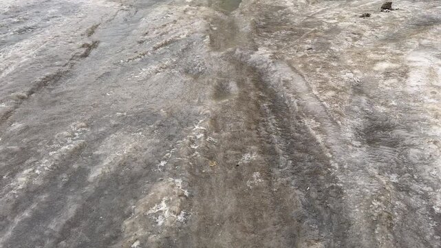 The road was covered with ice after the rain in the frost.