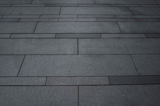Grey brick stone street road. Light sidewalk, pavement texture. Granite outdoor tiled floor.