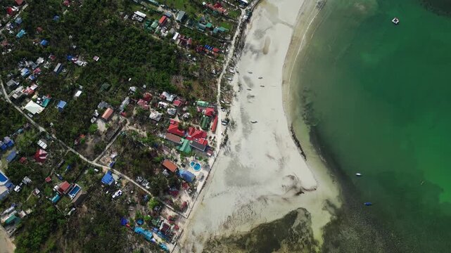 High wide aerial revealing the full island with palm trees, white sand shoreline, and clear surrounding water