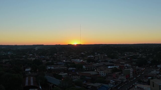 Dolly in aerial view at sunset showing Puerto Iguaz&uacute;&rsquo;s skyline and urban sprawl, with warm light over the tri border area