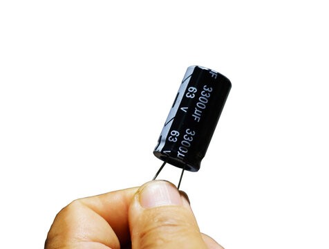 A close-up view of a black 3300uF 63V electrolytic capacitor held in a hand against a white background.