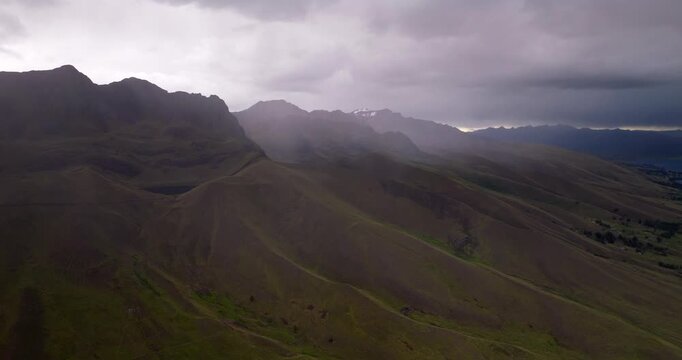 Misty Andean mountains and layered ridges under dramatic clouds near Laguna Langui Peru, aerial medium backdrop