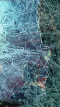 Vertical video: Curly-haired fan reaching stage, wristband sparking blue light trails during music