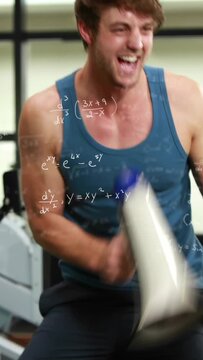 Vertical video: Male coach shouting with megaphone woman rower pulling hard fitness math overlaying