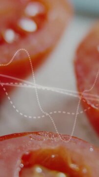 Vertical video: Dotted wave appearing, camera panning over tomato halves highlighting glossy seeds