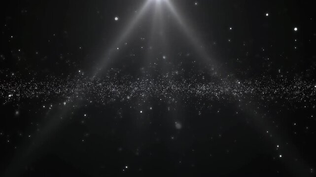 Dazzling light rays shining through sparkling particles in darkness.