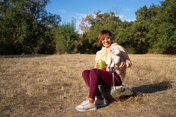 Senior Woman enjoying companionship with dog in nature park