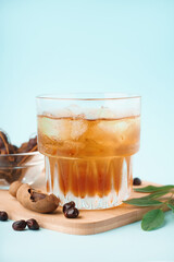 Obraz premium Glass of tasty tamarind drink and fruits on blue background