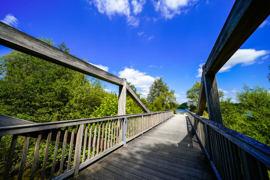 Pedestrian bridge at Lake Lippe and the surrounding green landscape. Nature by the lake near Paderborn.
