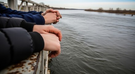 Obraz premium Close up hands river view from bridge railing, people standing by water watching flowing river current. Thoughtful hands river scene evokes quiet contemplation,