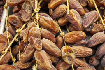 Obraz premium Clusters of dried dates with glossy skins illustrate a traditional Mediterranean sweet valued for natural sugars, dense texture, and frequent use in festive and everyday dishes.