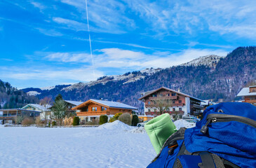 Trekkingrucksack vor winterlichem Ortsbild Walchsee