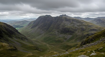 Dramatic view of craggy mountains and valley under a brooding, overcast sky