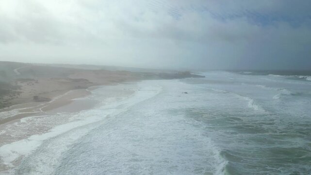 Aerial view of Guincho beach after Storm Kristin, showing the sea white and choppy due to beach erosion. Cascais,Portugal