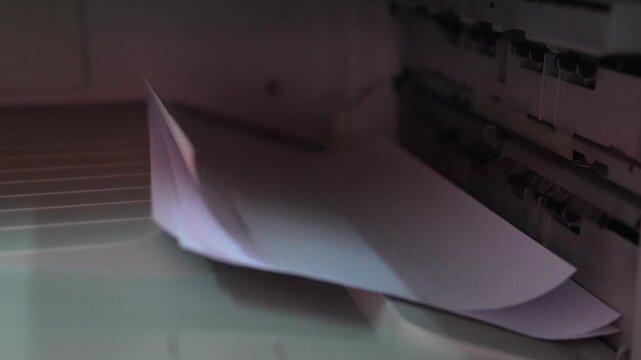 Closeup View of Paper Being Ejected from a Printer with a Soft Lighting Effect on the Device Surface