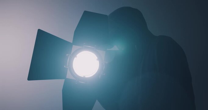 Lighting engineer setting up lights in film studio