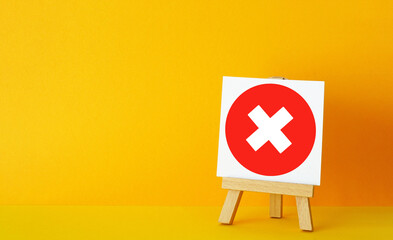 Red Cross Mark Icon on Small Wooden Easel with Yellow Background, Rejection, Denied Approval, Failure and Negative Decision Concept