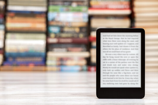 A close-up of an e-book with space for writing on the screen. an e-book against the background of paper books. modern electronic reader. 
