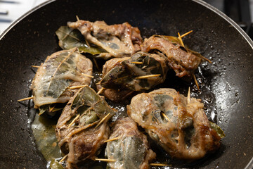 Pork livers with bay leaves in a net