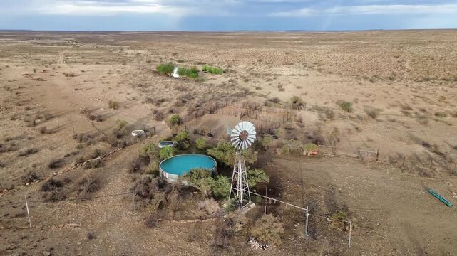 Camera circling a Wind pump and Semi-arid Karoo Landscape 4K Aerial Video.