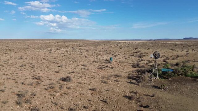 Camera circling a Wind pump and Semi-arid Karoo Landscape 4K Aerial Video.