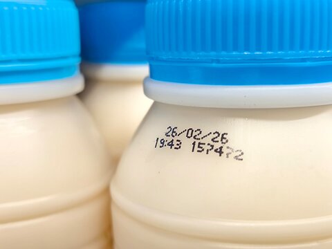Select focus of the expiration date stamped on milk bottle. Expire date. Dairy product. For manufacturing, quality control, packaging design, consumer goods, and product labeling