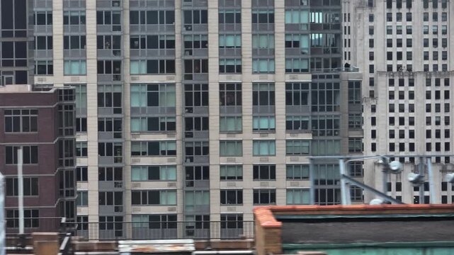 Telephoto drone shot sideways in middle of highrise in Midtown, cloudy day in NYC