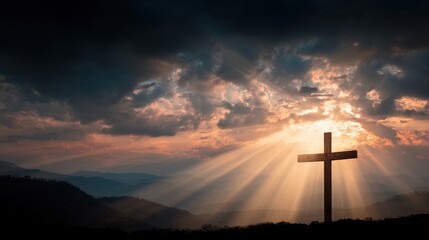 Cross stands on a hill with sun rays shining through clouds at dusk in a scenic landscape
