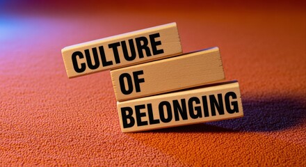 Obraz premium Culture of Belonging Conceptual Image: Wooden Blocks Displaying Text on Textured Surface, Representing Inclusion and Community