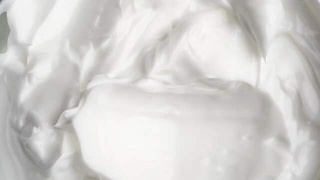 Cosmetic and beauty procedure concept. female finger scoops up textured white cream skincare.