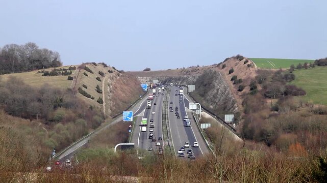 Traffic on the M3 Motorway as it cuts through hills near to Winchester England