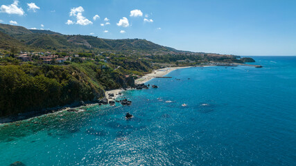 Aerial view of the Coast of the Gods, located on the Tyrrhenian coast of Calabria, Italy. In the foreground, the beautiful Mediterranean Sea. On the horizon, the town of Tropea, in province of Vibo.
