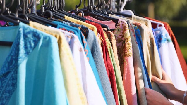 Colorful Indian bazaar clothing: a hand browsing traditional textiles for shopping