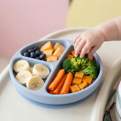 Baby finger food plate with soft fruits and steamed vegetables, pastel background