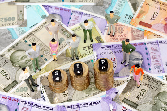 Systematic Investment Plan-SIP blocks on stack of coins and human figurine