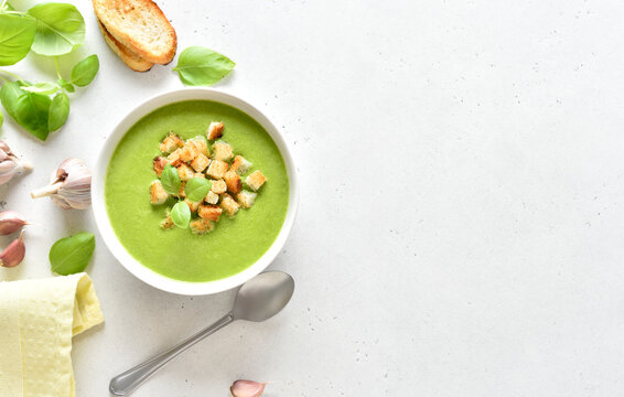Spinach soup with croutons in white bowl
