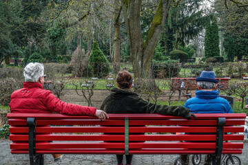 Familie sitzt auf dem Friedhof auf einer Bank