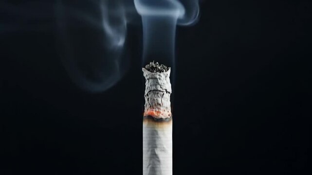Close-up of a lit cigarette with rising smoke against a dark background