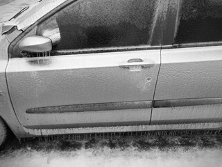 Eis und Eiszapfen an einem zugefrorenen Fahrzeug
