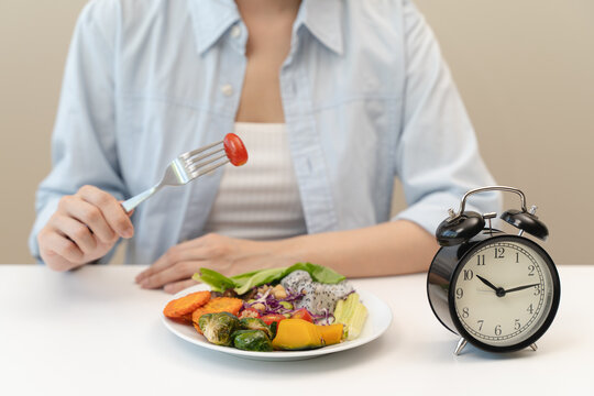Intermittent fasting concept, Close-up on clock and people feeling hungry waiting time to eat during intermittent fasting diet session