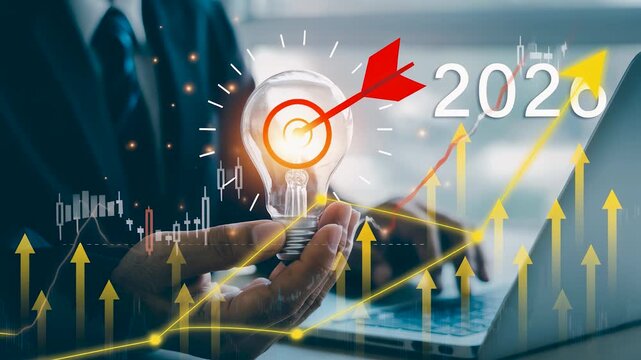 Businessman hand holding light bulb with target icon and new year 2026 financial growth arrow graph. Concept involves corporate business strategy goal achievement and future year innovation planning.