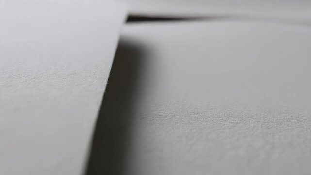 Macro shot of textured white paper overlap creates shadow play